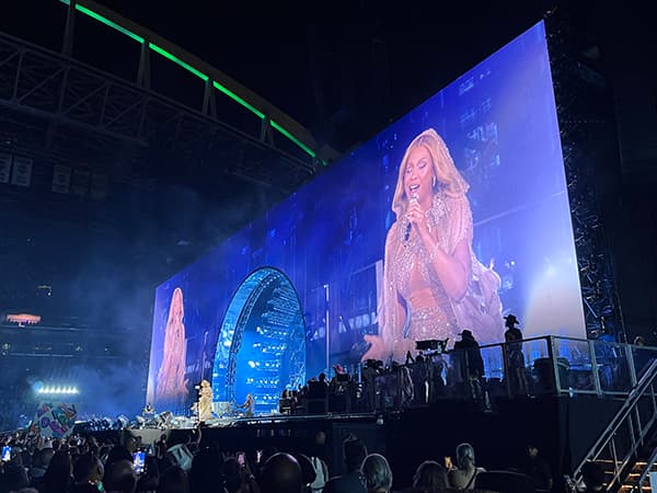 Performance by Beyonce as seen from the front row. A large display screen shows the performance from multiple angles with an archway built in the middle.